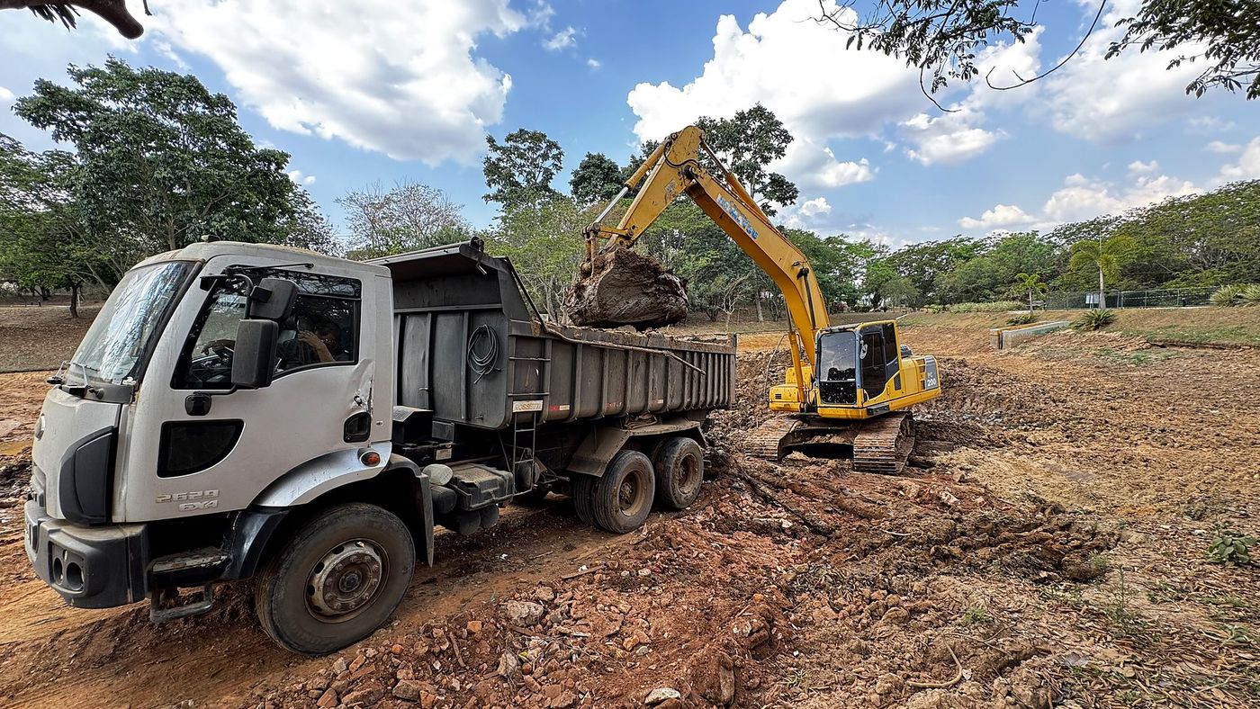 Escavadeira carregando caminhão basculante em obra de desassoreamento executada pela PGRS Brasil