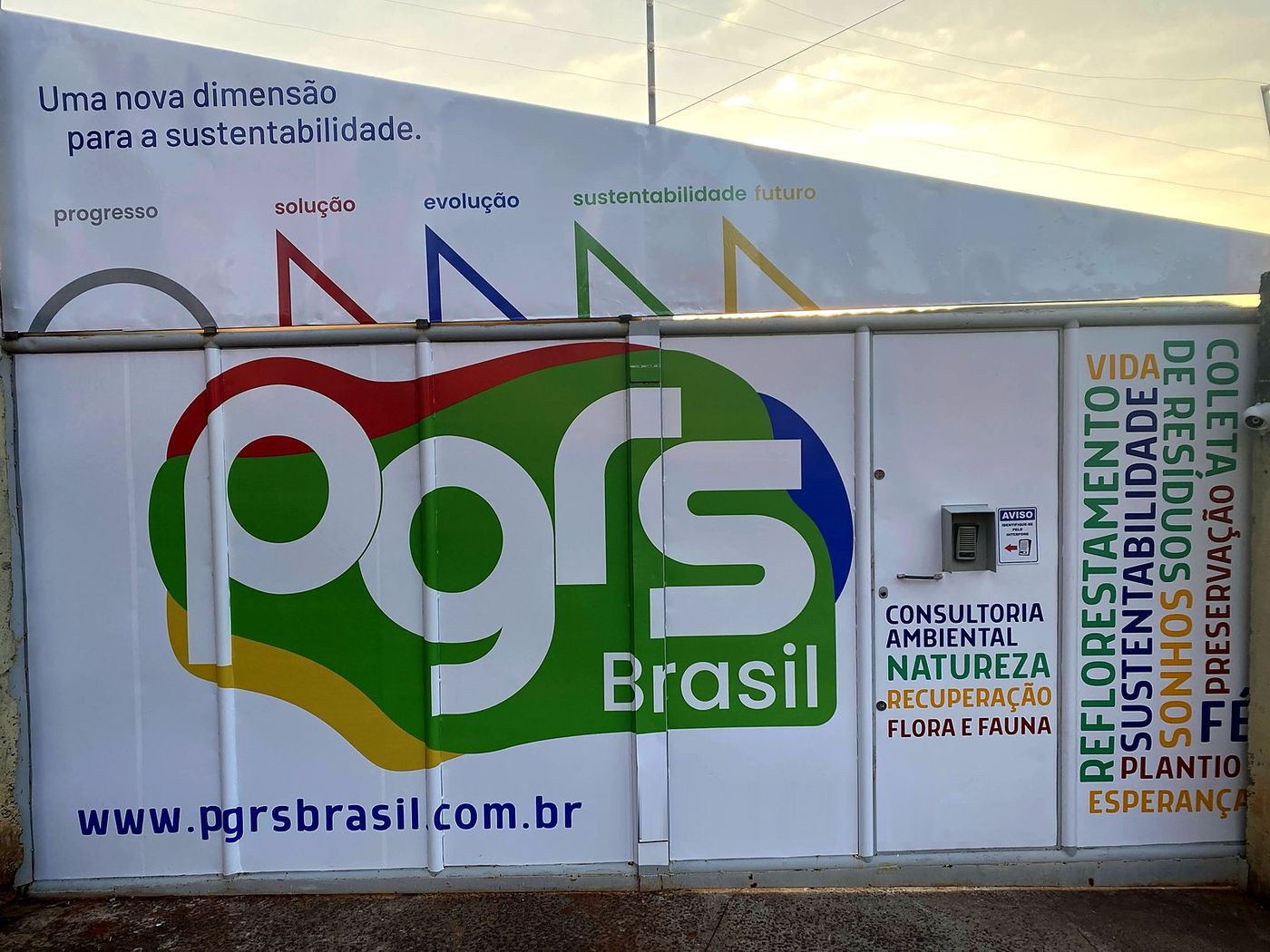 Portão da base da PGRS Brasil com a logo e o site pgrsbrasil.com.br